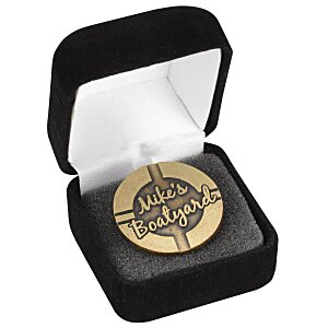 Round branded lapel pin inside open gift box
